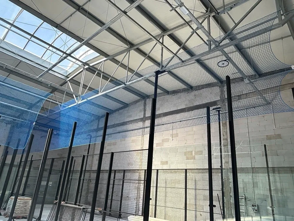 Zadaszone korty do padla z szkleniami panoramicznymi w nowoczesnej hali sportowej